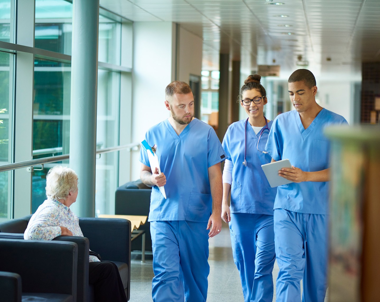 providers in scrubs walking down hallway and talking