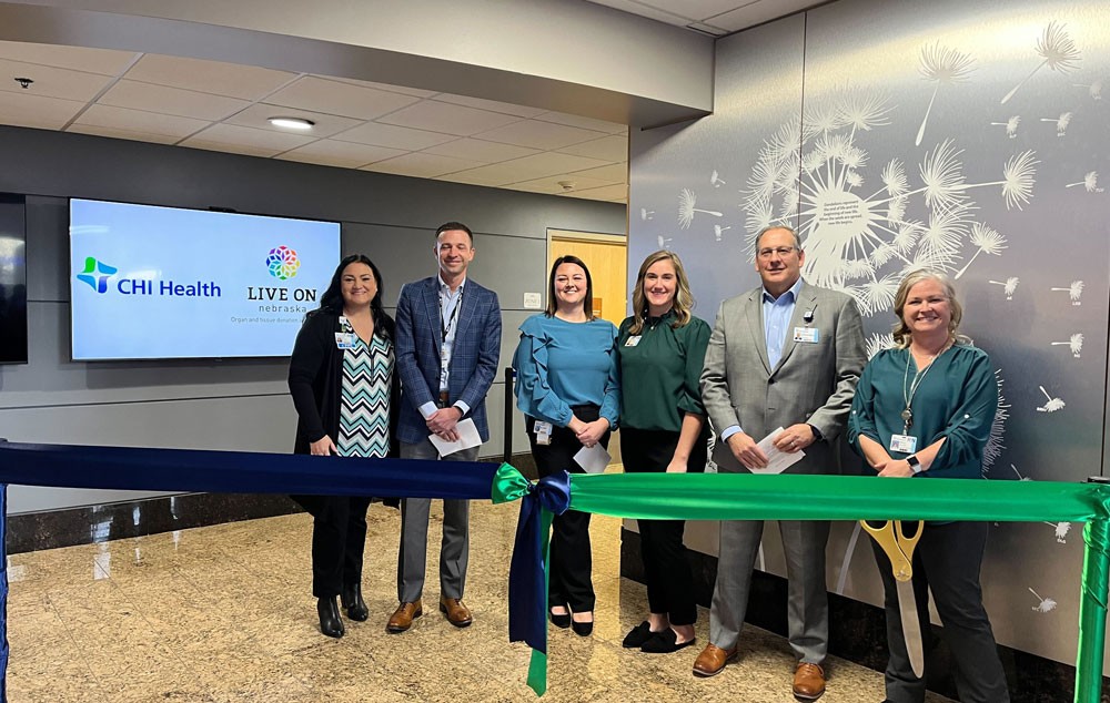 The Gift of Life: CHI Health to Open New Donor Care Unit Group cutting ribbon in front of donor wall