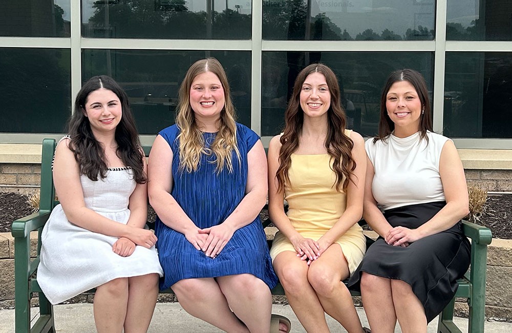 Group photo of four people on a bench