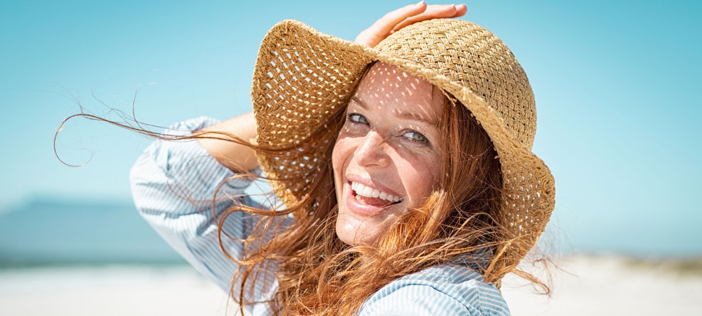 Smiling woman with red hair and straw hat