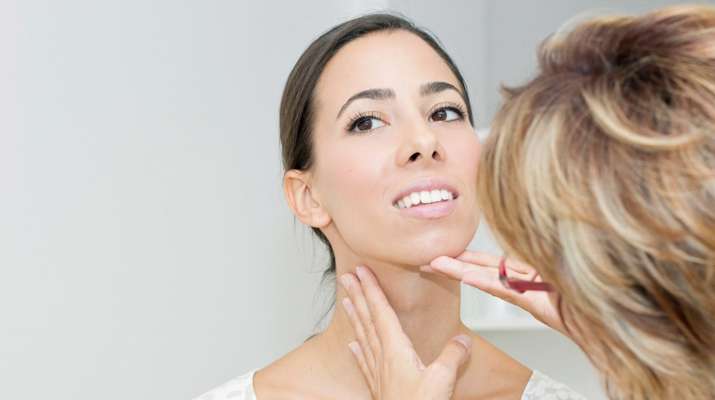 Woman having her throat examined by a doctor