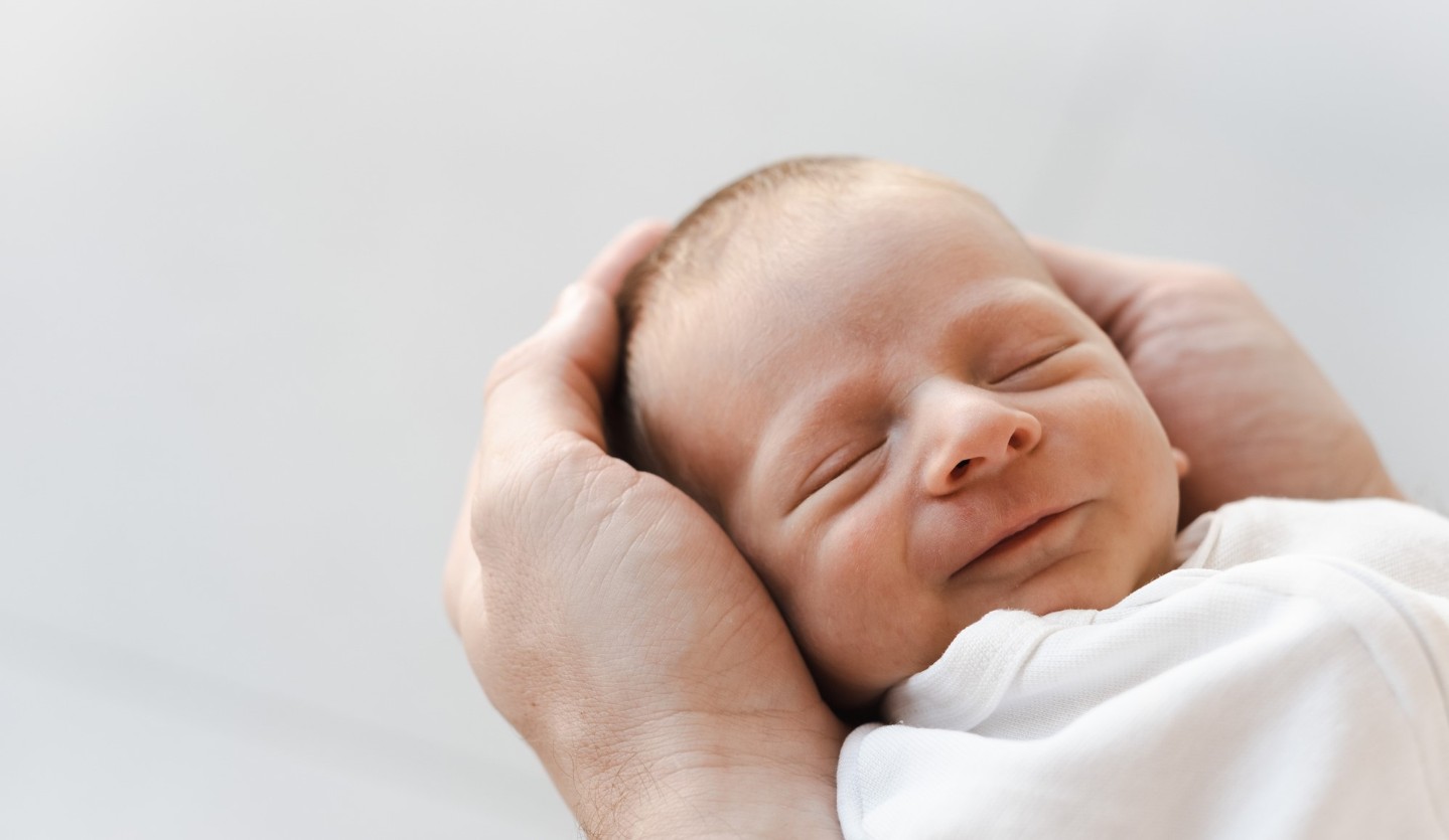 Smiling and sleeping newborn baby