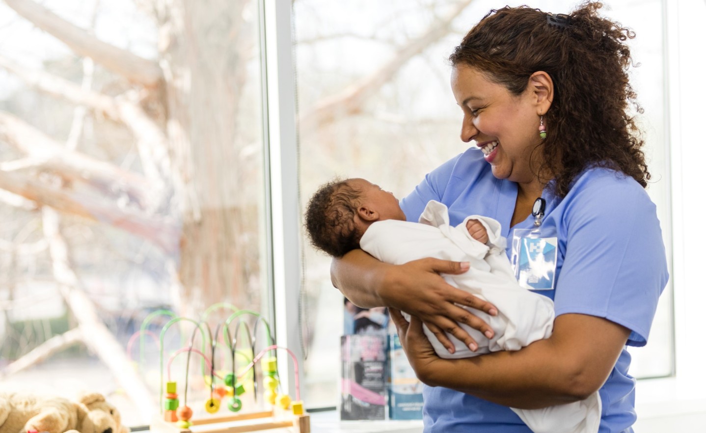 Happy nurse holding a newborn baby