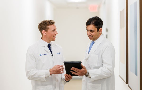 Dr. Green and Dr. Gupta standing in a hallway talking