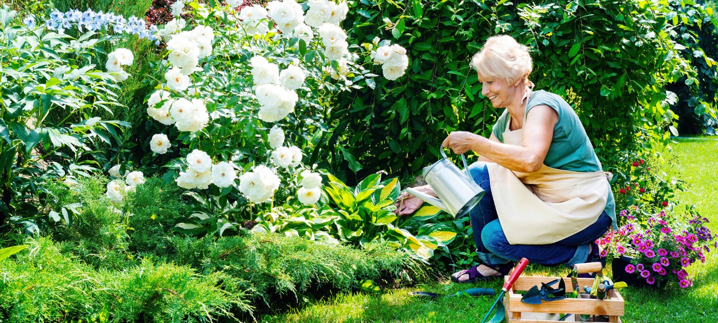 Older woman kneeling in her garden